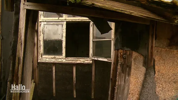 Blick in eine verfallende Holzbaracke