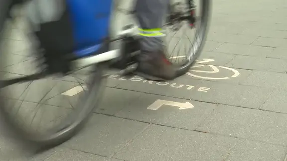 Ein Radfahrer fährt über einen Fahrradweg.