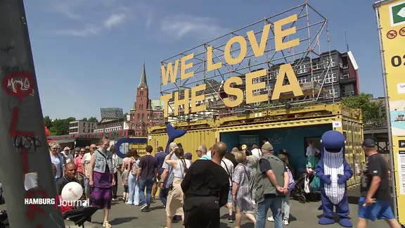 "We love the Sea", steht in großen gelben Buchstaben am Hamburger Hafen.