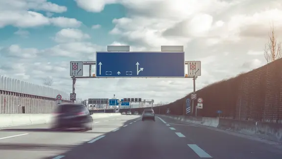 Eine Autobahn mit Schildern und Autos.