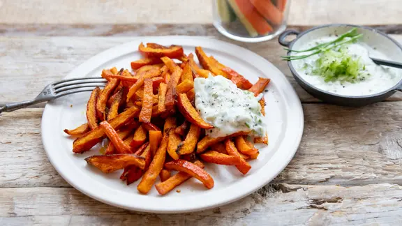 Ein Teller mit Kürbis-Pommes und Joghurt-Dip.