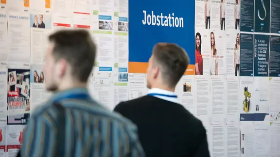 Studierende informieren sich an der Jobstation über mögliche Berufe.