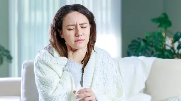 Halsschmerzen mit Schluckbeschwerden: Frau hält sich den Hals und verzieht das Gesicht vor Schmerzen. | colourbox.de Halsschmerzen mit Schluckbeschwerden: Frau hält sich den Hals und verzieht das Gesicht vor Schmerzen.