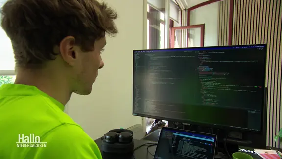 Ein junger Mann sitzt am Computer.
