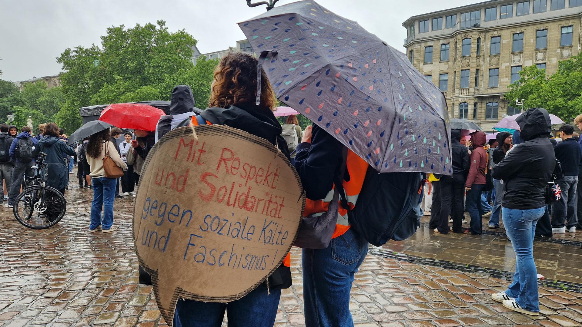 Zwei Schülerinnen stehen nebeneinander und auf einem Pappschild steht: 
