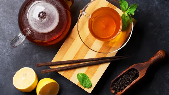 Tee in einer Glaskanne und Tasse - mit Zitrone und Melisse dekoriert. | fotolia.com, karandaev Tee in einer Glaskanne und Tasse - mit Zitrone und Melisse dekoriert.