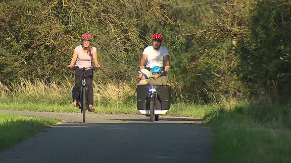 Eine Familie fährt mit Fahrrädern durchs Wendland.