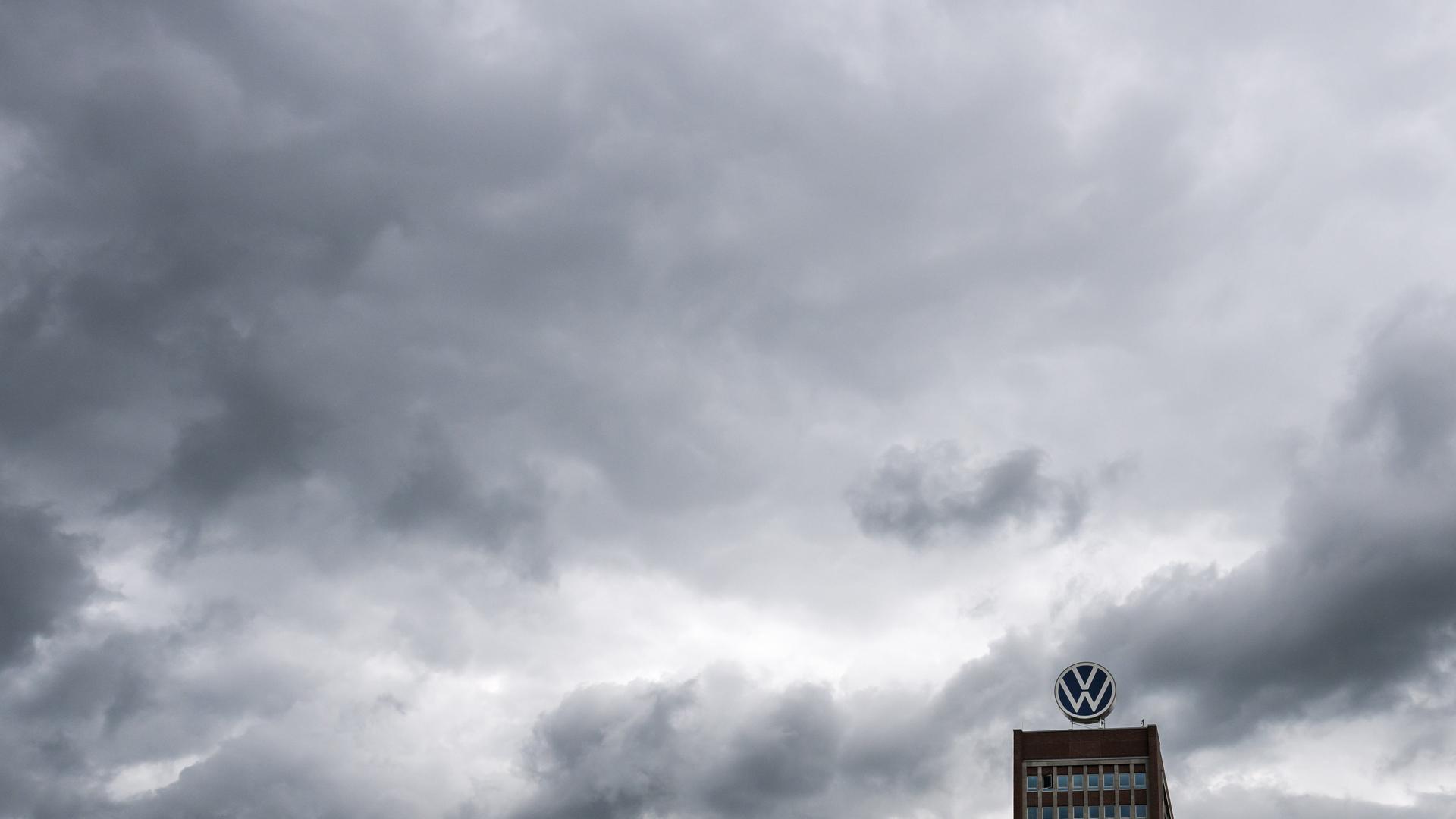 Dunkle Wolken ziehen über das Markenhochhaus auf dem Gelände vom VW Werk Wolfsburg hinweg. | picture alliance/dpa/Julian Stratenschulte, Julian Stratenschulte