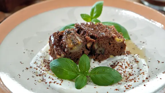 Buchweizen-Bananenbrot mit Joghurt und Basilikum auf einem Teller serviert