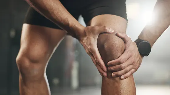 Kreuzbandriss: Sportler hält das schmerzendes Knie