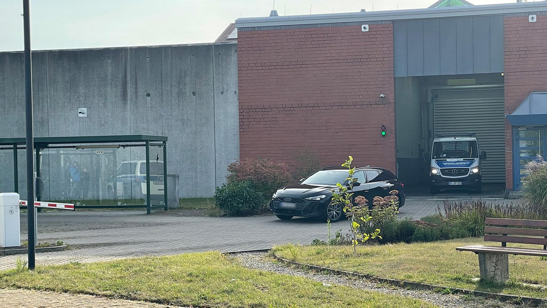 Ein Auto fährt in Begleitung eines Polizeifahrzeuges vom Gelände der JVA Sehnde. | NDR/Vera Zellmer