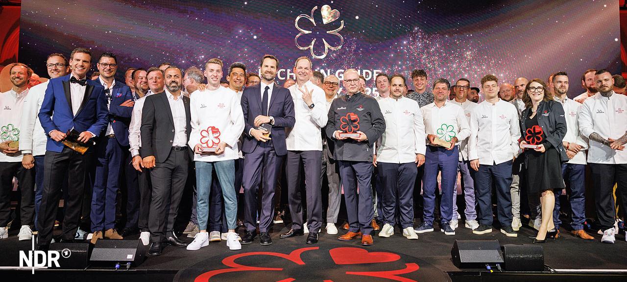 Die Preisträger der Verleihung der Guide-Michelin-Sterne 2025 für deutsche Restaurants stehen bei einem Gruppenbild zusammen.