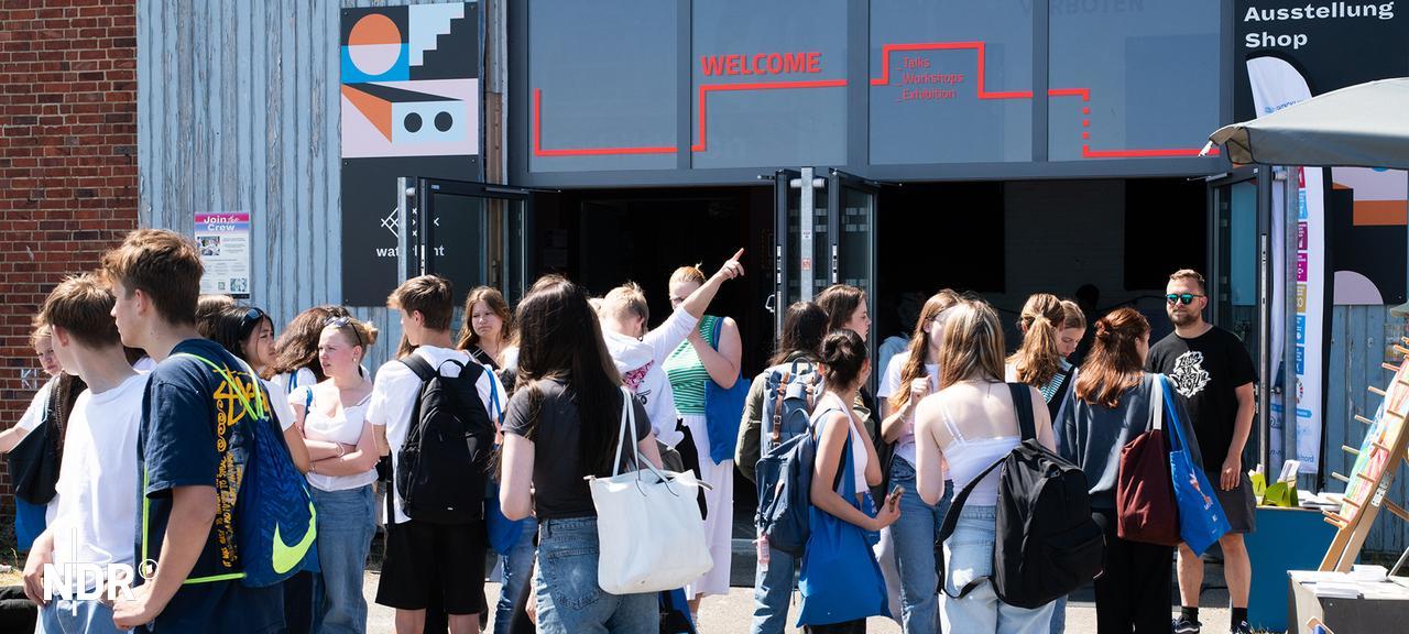 Junge Menschen stehen am Eingang zum Young Waterkant Festival in Kiel. | SEEDs Junge Leute stehen am Eingang zum Young Waterkant Festival in Kiel