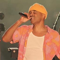 Der Berliner Musiker Patrice singt gefühlvoll in ein Mikrofon auf der Kieler Woche 2024.
