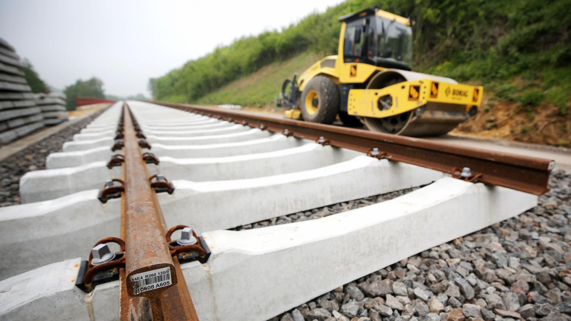 An einem Gleis finden Sanierungsarbeiten statt, daneben steht ein Baufahrzeug. | picture alliance/dpa | Roland Weihrauch