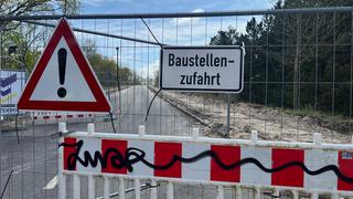 Vor der Baustellenzufahrt an der Decatur-Brücke in Maschen stehen ein Bauzaun und Warnschilder.