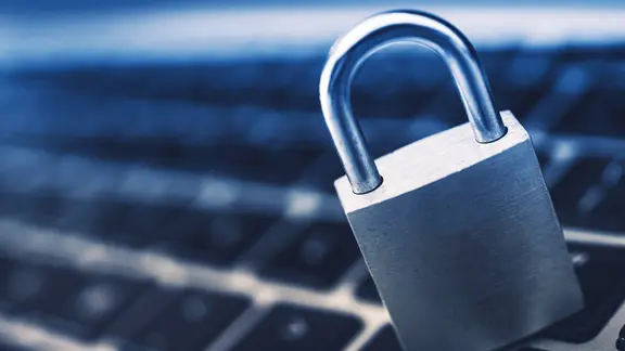 Ein Vorhängeschloss vor einer Computertastatur