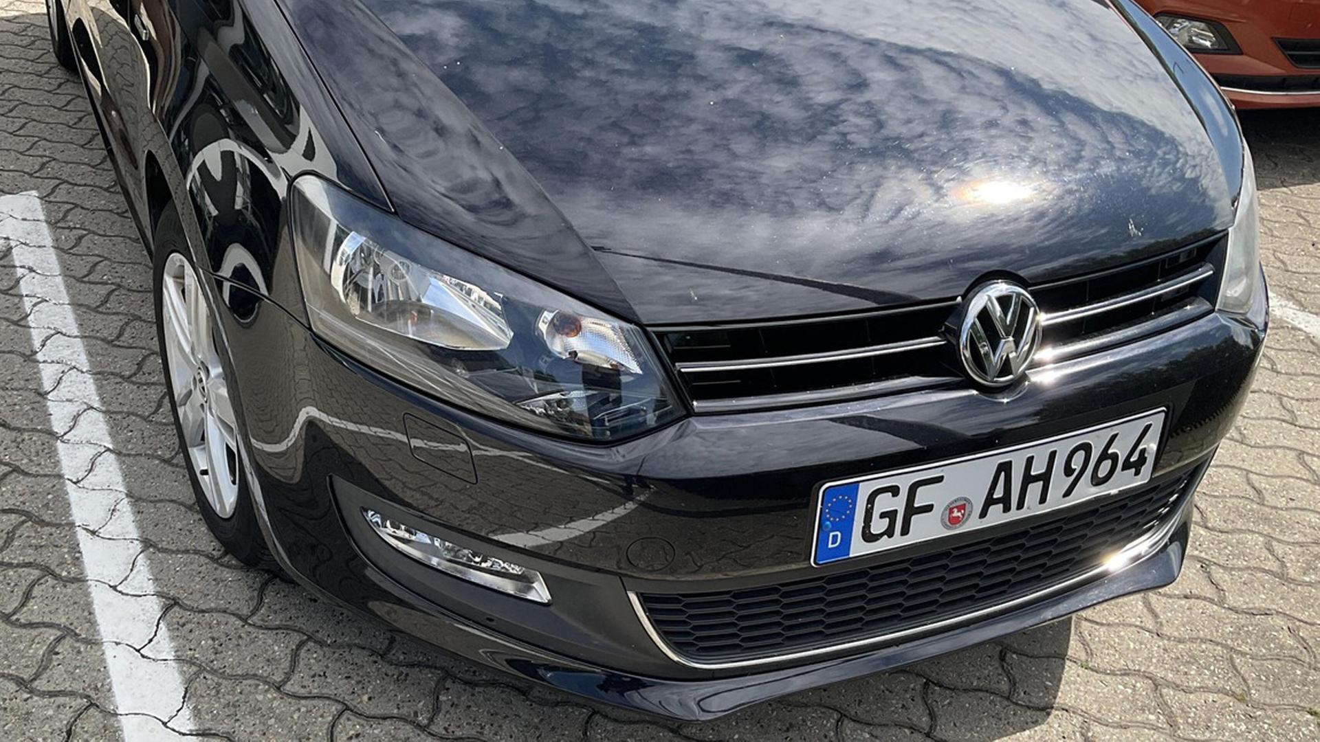 Auf einem Nummernschild eines schwarzen VW Polo steht 