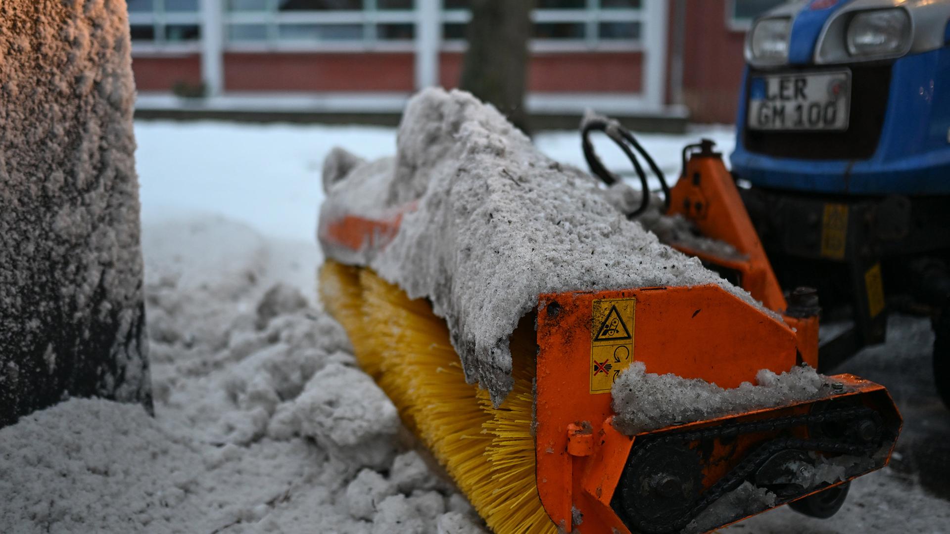 Am Teletta-Groß-Gymnasium räumt der Hausmeister den Schnee vom Schulhof. | dpa, Lars Penning