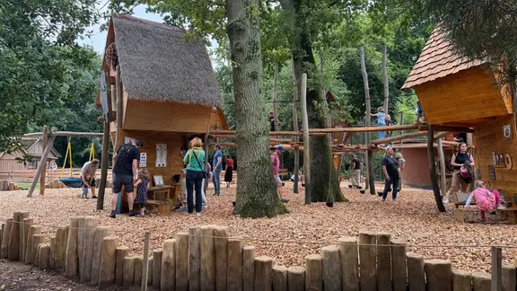 Kinder und Erwachsene spielen auf dem neuen Hauptspielplatz im Schweriner Zoo