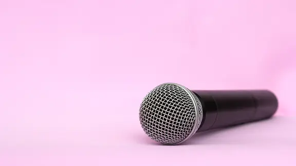 Ein Mikrofon vor rosa Hintergrund.