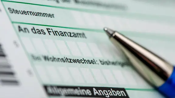 Ein Kugelschreiber liegt auf einem Steuerformular für ein Finanzamt | IMAGO / Wolfilser Ein Steuerformular mit einem Kugelschreiber
