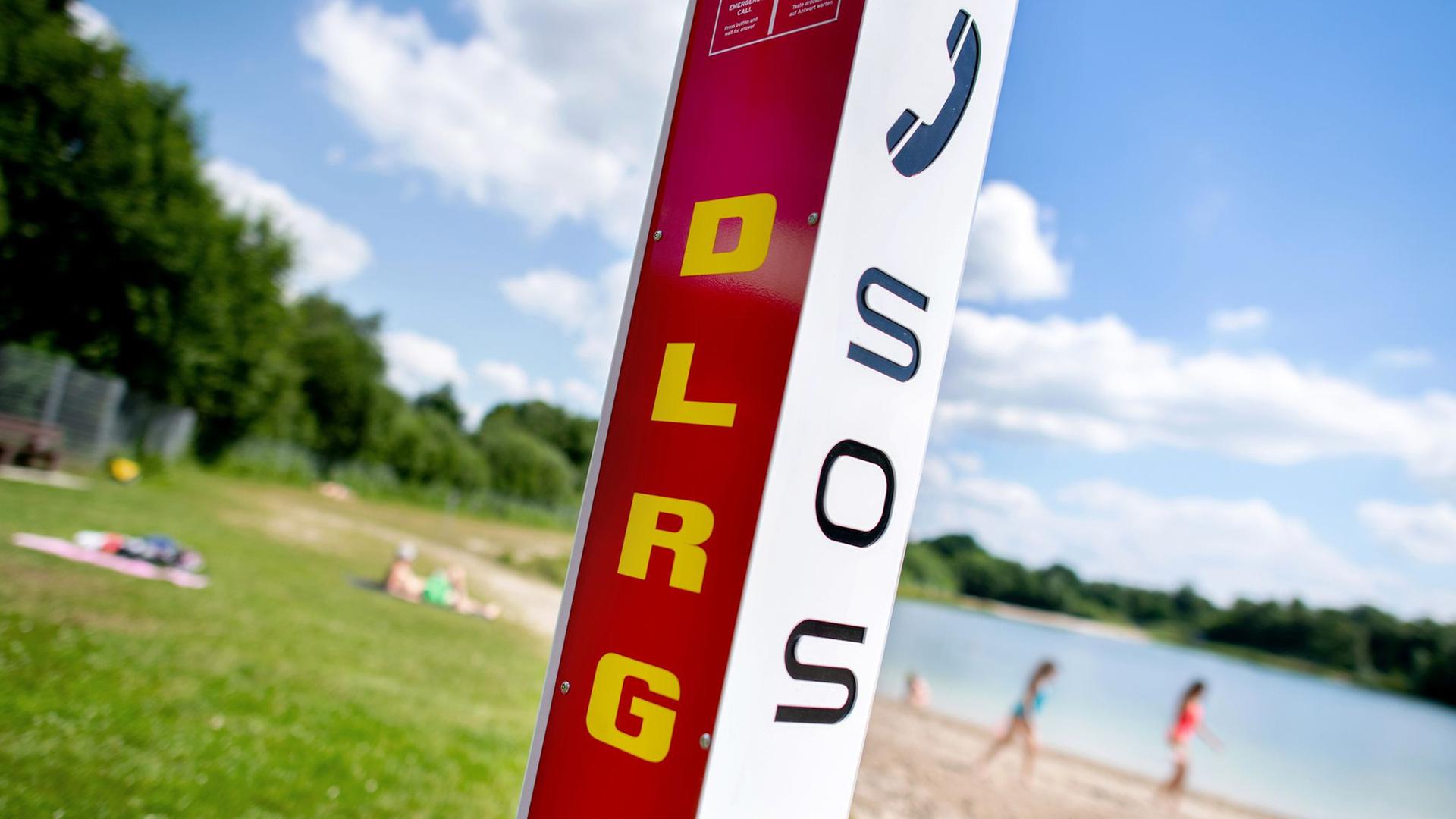 Eine Notrufsäule der DLRG steht an einem Badesee. | dpa, Hauke-Christian Dittrich