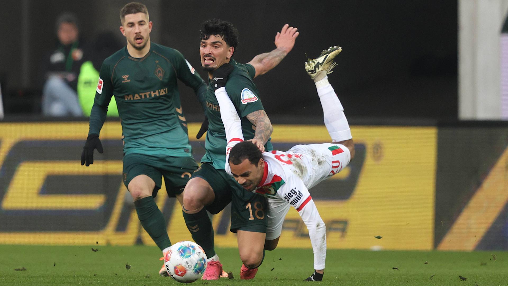 Werder-Profi Cameron Puertas (M.) im Zweikampf mit Augsburgs Alexis Claude-Maurice | IMAGO/Oryk HAIST