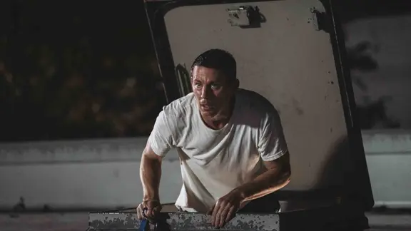 Szene aus dem Film "Der Hochstapler - Roofman": Ein Mann klettert durch eine Dachluke