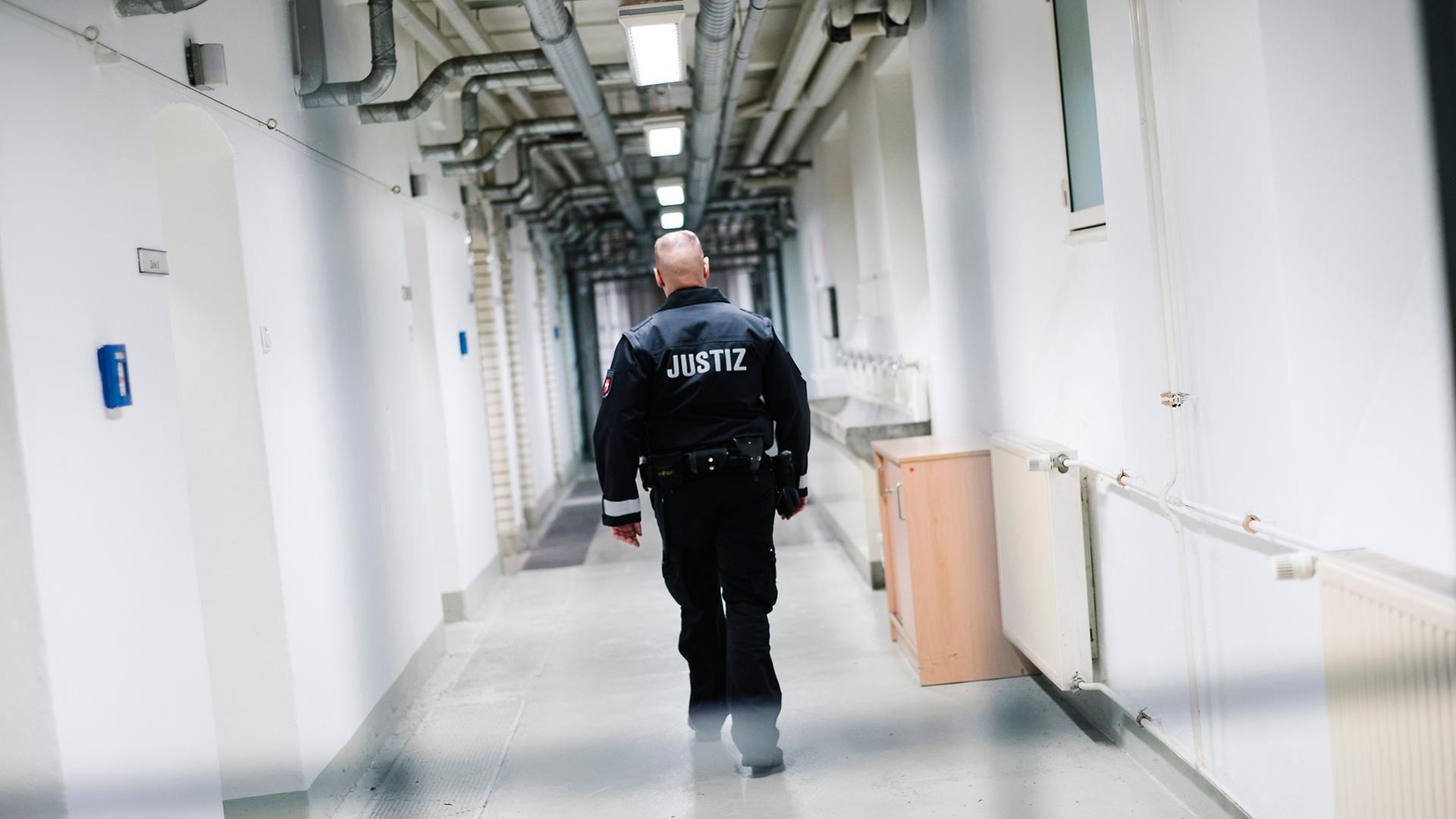 Ein Beamter des Justiz Vollzuges geht durch einen Gang in einem Gefängnistrakt. | NDR, Julius Matuschik