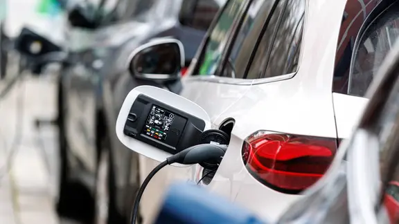 E-Autos verschiedener Hersteller sind am 16.12.2025 an Ladesäulen am Straßenrand im Stadtzentrum von München (Bayern) angeschlossen.