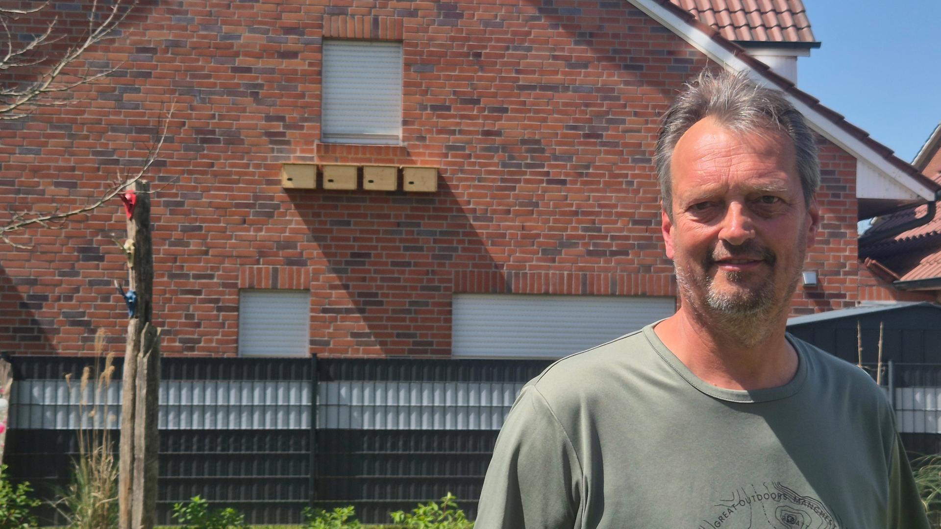 Rainer Strübbe aus Lingen steht vor den Nistkästen an seiner Hauswand und blickt in die Kamera. | NDR, Britta Nareyka
