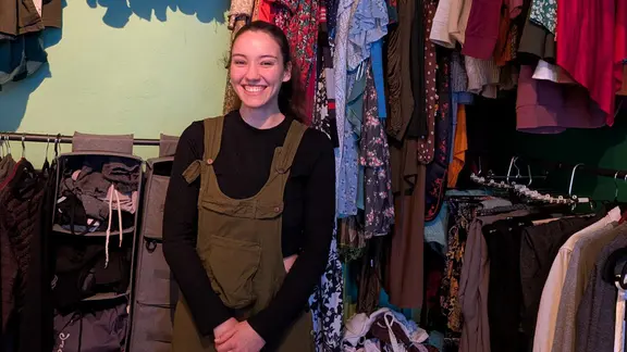 Eine junge Frau steht in einem begehbaren Kleiderschrank.