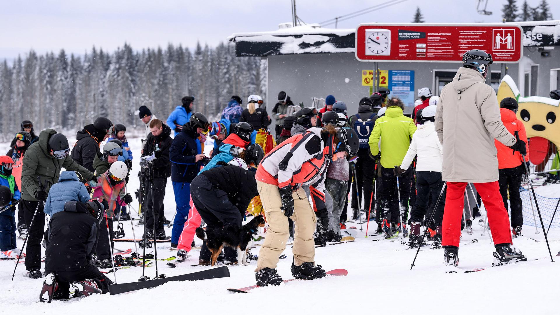 Skifahrer und Snowboarder warten auf den Liftbetrieb am Wurmberg.  | dpa, Swen Pförtner