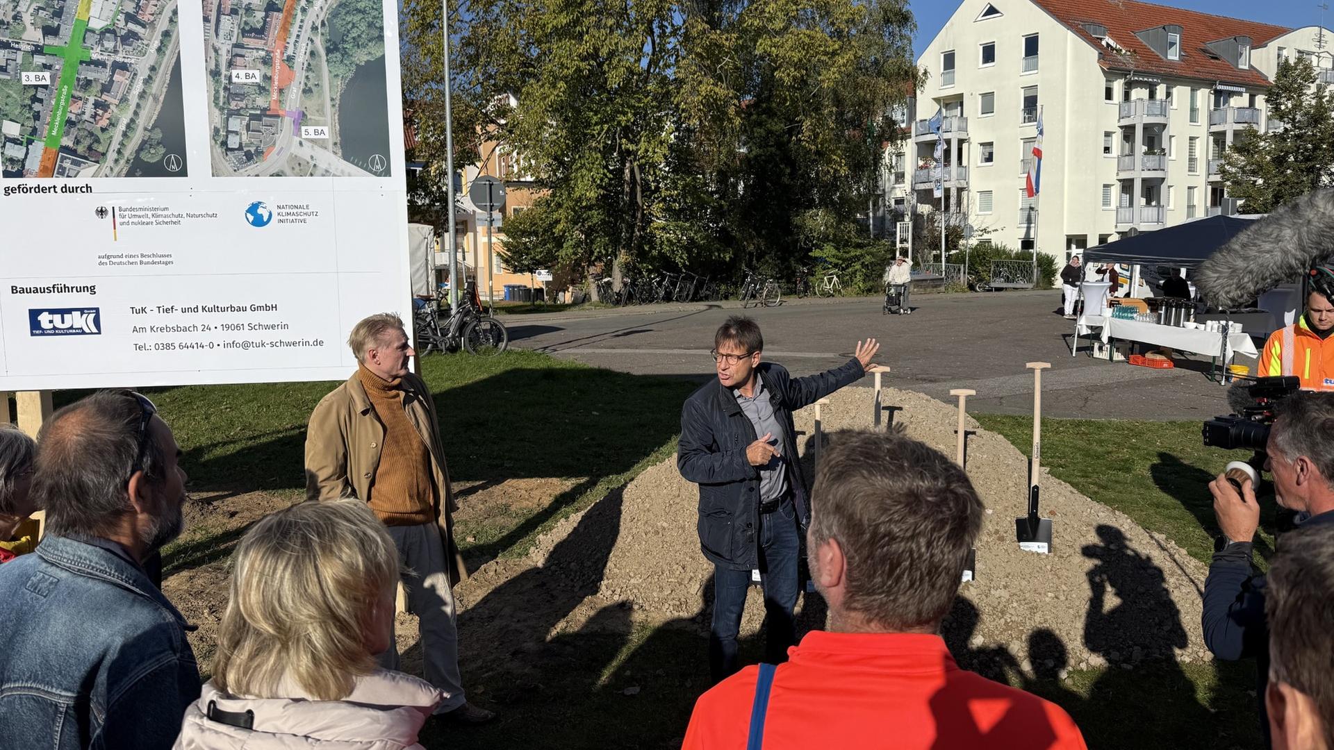 Mehrere Menschen stehen um eine Baustelle herum. | NDR, Christoph Kümmritz