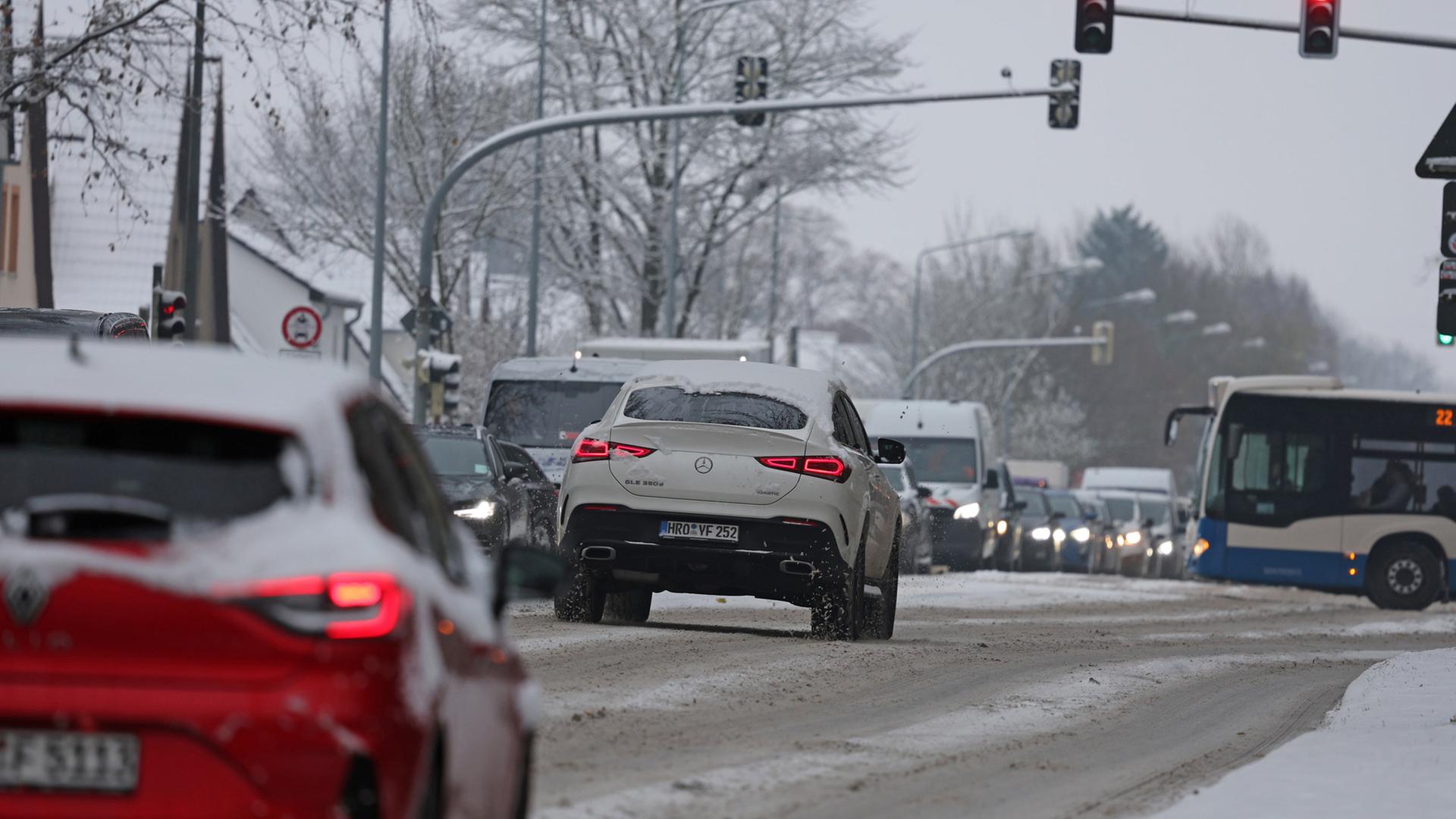 Verschneite Straße in Rostock mit sich stauendem Verkehr | Bernd Wüstneck/dpa