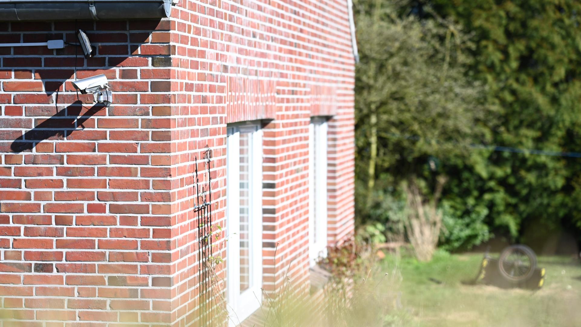 Blick auf das Grundstück in Holtgast, wo die Leiche vergraben war. Ein Haus neben einer Rasenfläche.  | picture alliance/dpa | Lars Penning