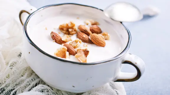 Mandeln eignen sich ideal, um Müsli, Joghurt oder Quark zu verfeinern. | Colourbox Eine Schale Skyr, darauf verteilt Mandeln und gehackte Nüsse.