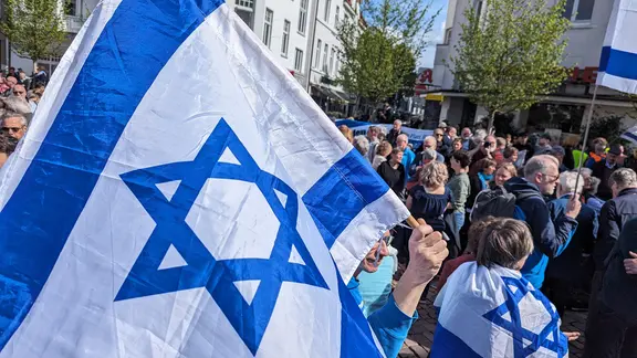 Bei einer Solidaritätsdemonstration in Oldenburg wird eine israelische Flagge hochgehalten.