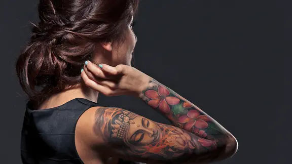 Nahaufnahme einer jungen Frau von hinten mit einem tätowierten Arm. | Colourbox, Dean Drobot Nahaufnahme einer jungen Frau von hinten mit einem tätowierten Arm.