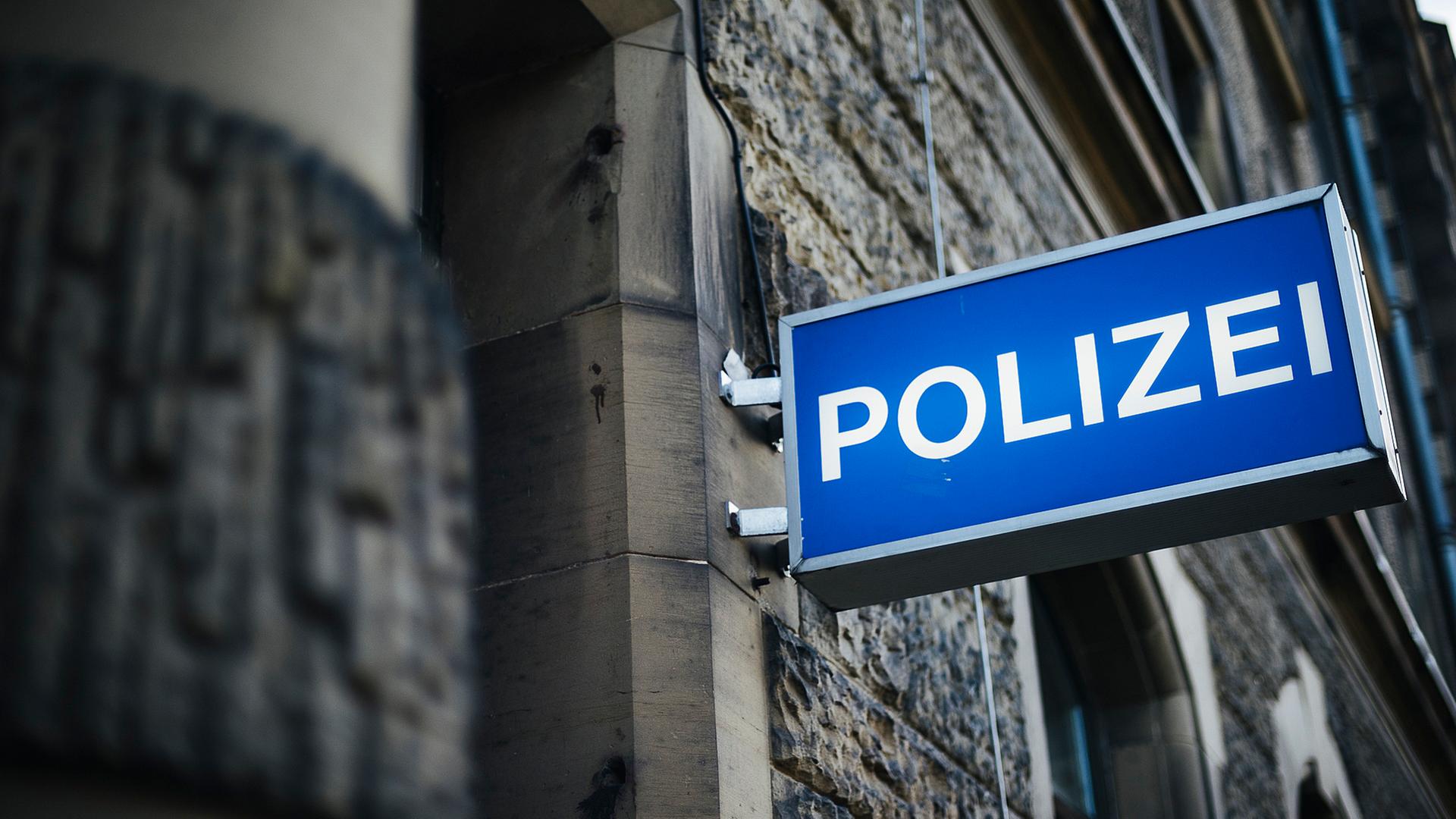 An einer Hausfassade hängt ein Leuchtschild mit der Aufschrift Polizei. | NDR, Julius Matuschik