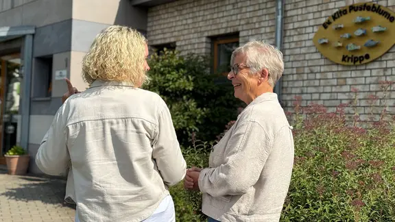 Zwei Frauen stehen vor einer Kita