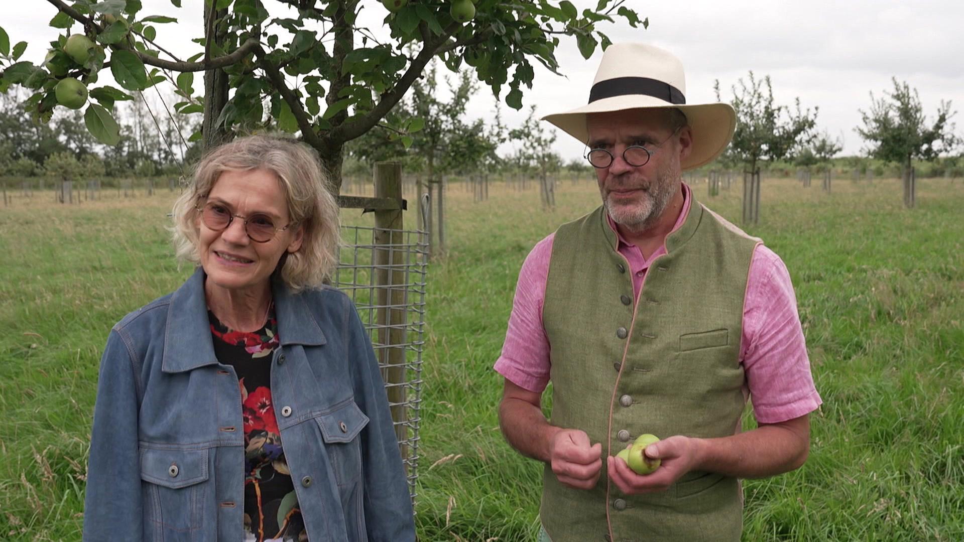 Eva Dengler und Lothar Müller stehen auf einer Streuobstwiese, er hält einen Apfel in der Hand. | NDR