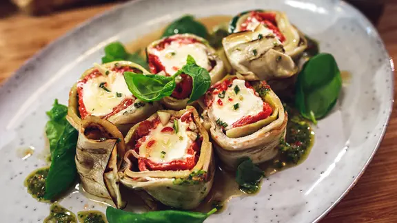 Gefüllte Gemüse-Röllchen auf einer Platte serviert.