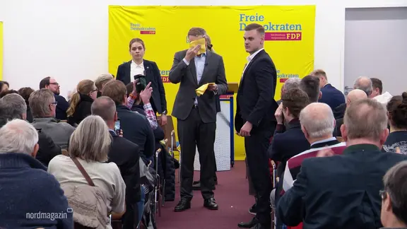 Bei einer Wahlkampfveranstaltung der FDP: Christian Lindner wischt sich mit gelben Servietten das Gesicht ab.