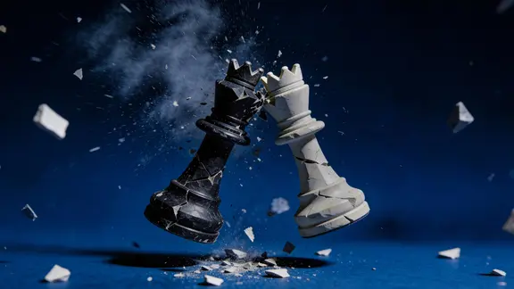 Schwarzer und weißer Schachkönig krachen zusammen, zerbrechen in Splitter vor blauem Hintergrund.