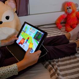 Ein junges Kind spielt das Spiel "Roblox" auf einem iPad.