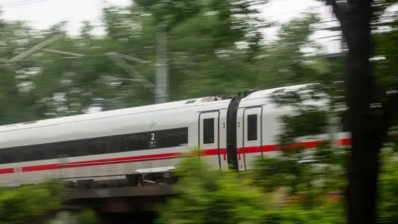 Ein ICE der Deutschen Bahn fährt schnell durch ein Waldgebiet. | picture-alliance/dpa | Fernando Gutierrez Juárez Ein ICE der Deutschen Bahn fährt schnell durch ein Waldgebiet.