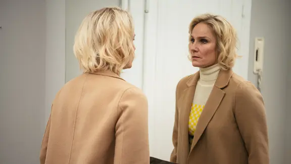 Linda (Laura Malmivaara) denkt über Auswege aus ihrer finanziellen Krise nach. | © ZDF und Jaakko Kahilaniemi. Eine Frau betrachtet nachdenklich ihr Spiegelbild