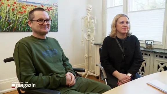 Ein Ukrainer im Rollstuhl sitzt neben einer Frau.